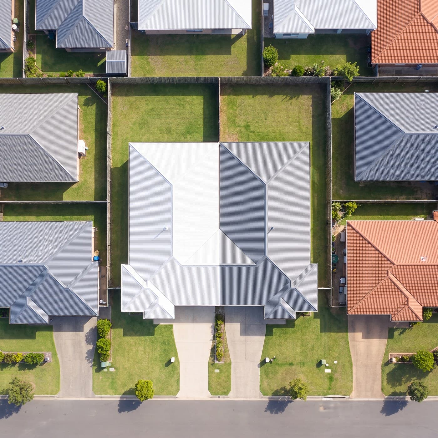 Aerial view of a duplex with two driveways and a divided back yard.