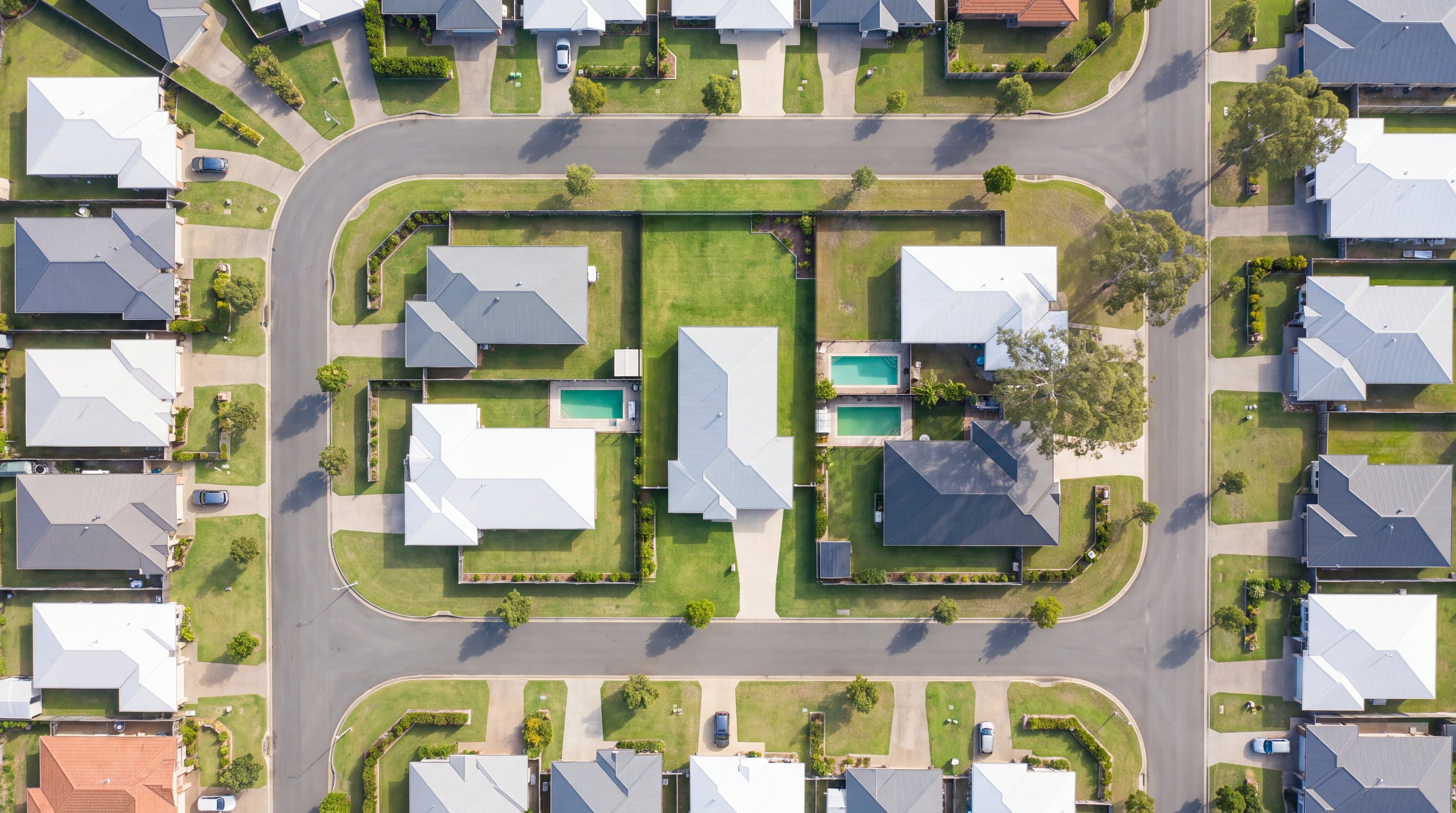 Aerial view of a quiet Australian suburb with a single home's lot at the centre.